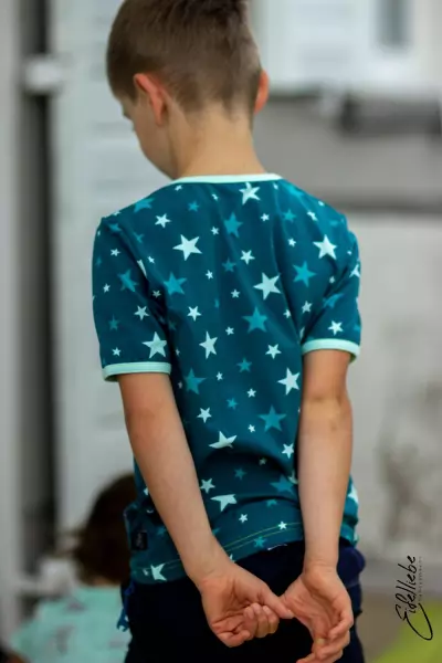 Tragebild Baumwolljersey mit bunten Sternen in der Farbe petrol